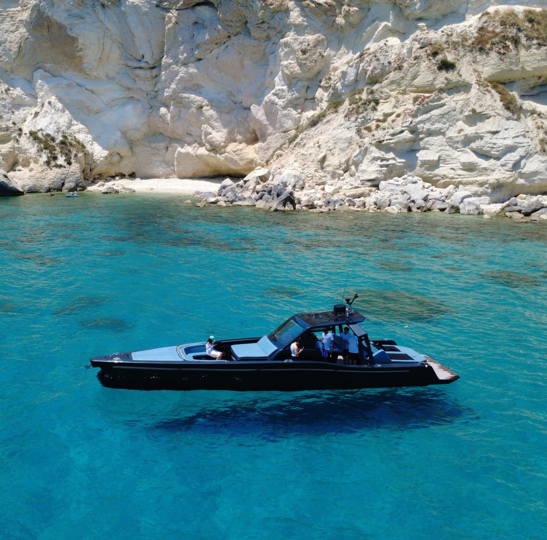 Black yacht in a limestone cove
